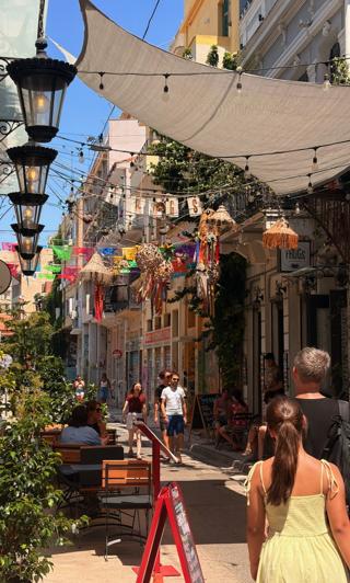 A street with colourful decorations strung above it.